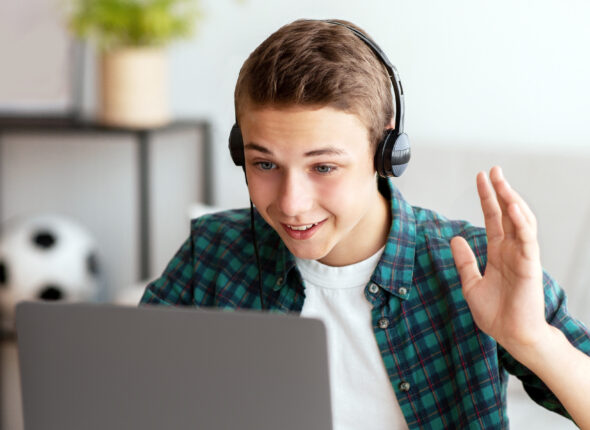 Positive teenager having video conference with teacher